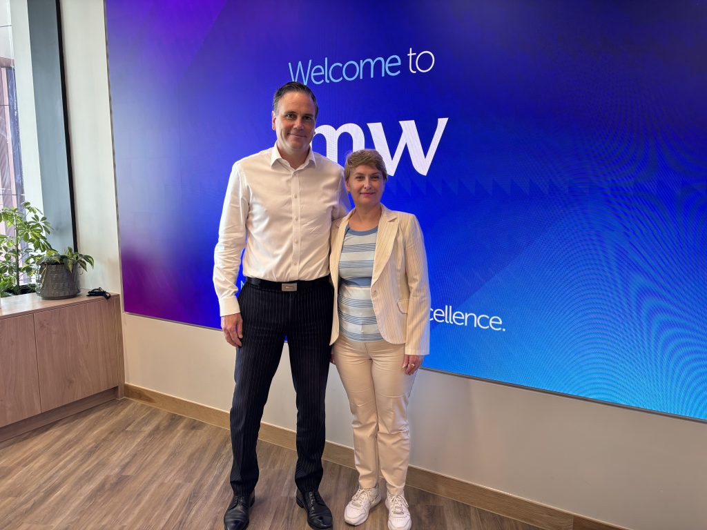 Dina Railean, Honorary Consul of the Republic of Moldova in Manchester and CEO of Moldovan Diaspora Business Alliance Ltd together with Stuart Cartwright, Partner at JMW Solicitors stand together at JMW Solicitors' Manchester office in front of a large "Welcome to JMW" display. The meeting focused on strengthening support for the Moldovan diaspora in the United Kingdom by exploring access to legal services through JMW Solicitors and its Lawshare network. Discussions also covered future collaboration between the Honorary Consulate of the Republic of Moldova in Manchester, Moldovan Diaspora Business Alliance Ltd, and JMW Solicitors to help connect Moldovan citizens and businesses with trusted legal advice across a wide range of practice areas.